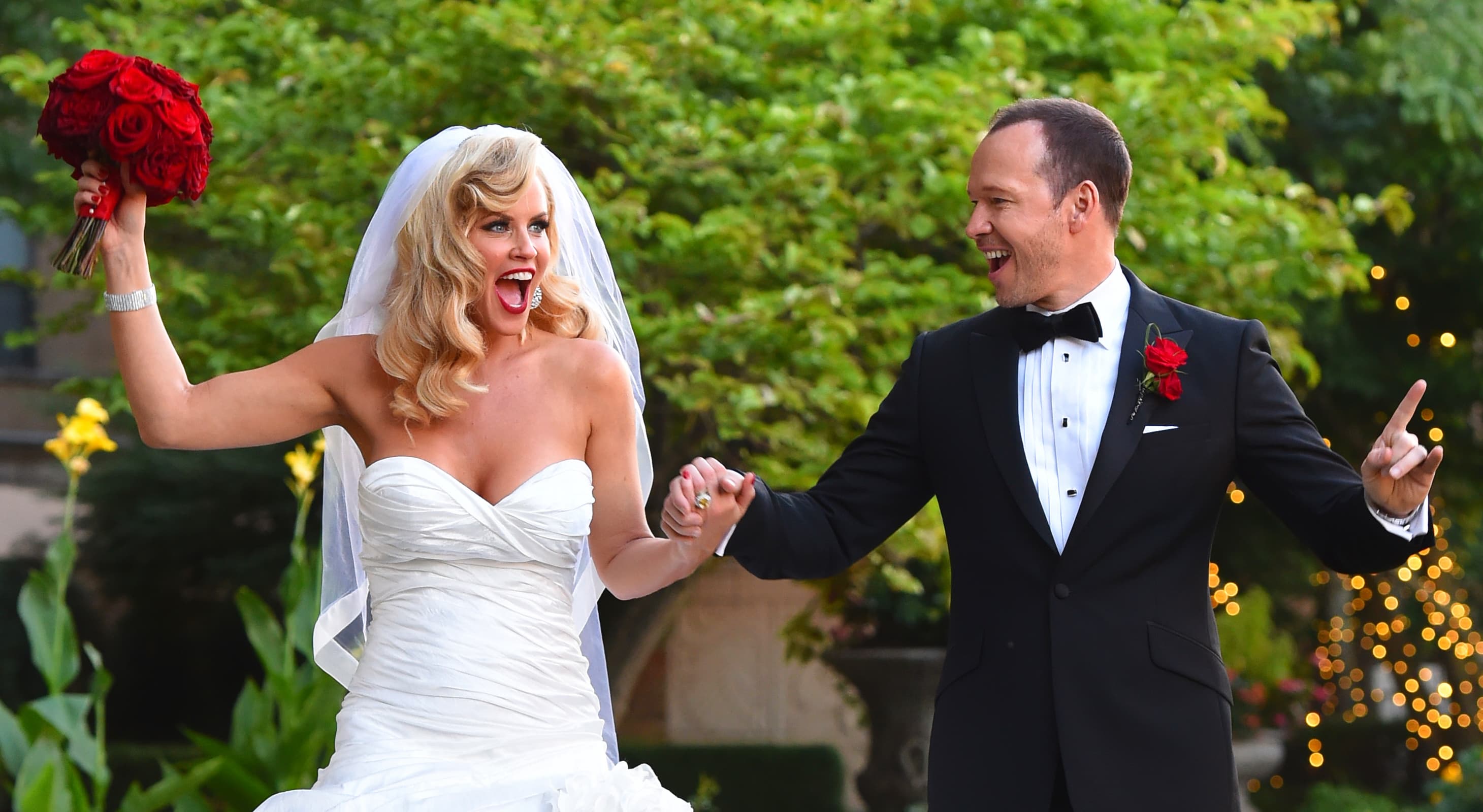 Donnie Wahlberg and Jenny McCarthy hold hands in the rose garden at Hotel Baker for their wedding reception
