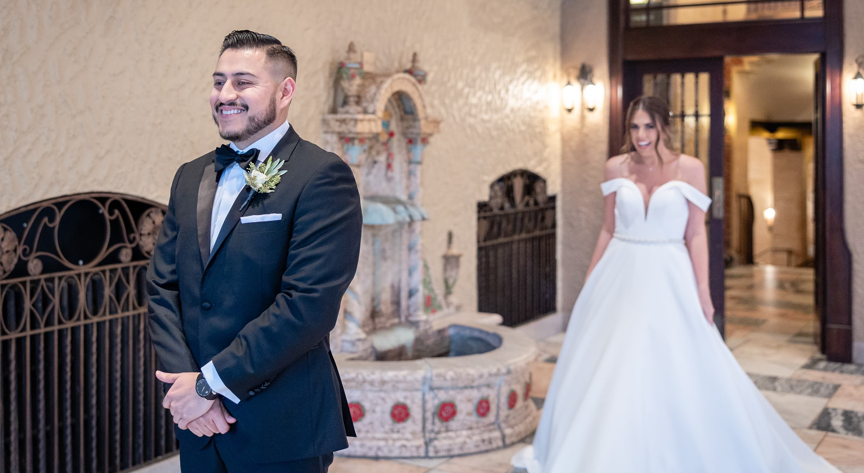 Bride walking up behind groom in the Waterfront Room, for the first look